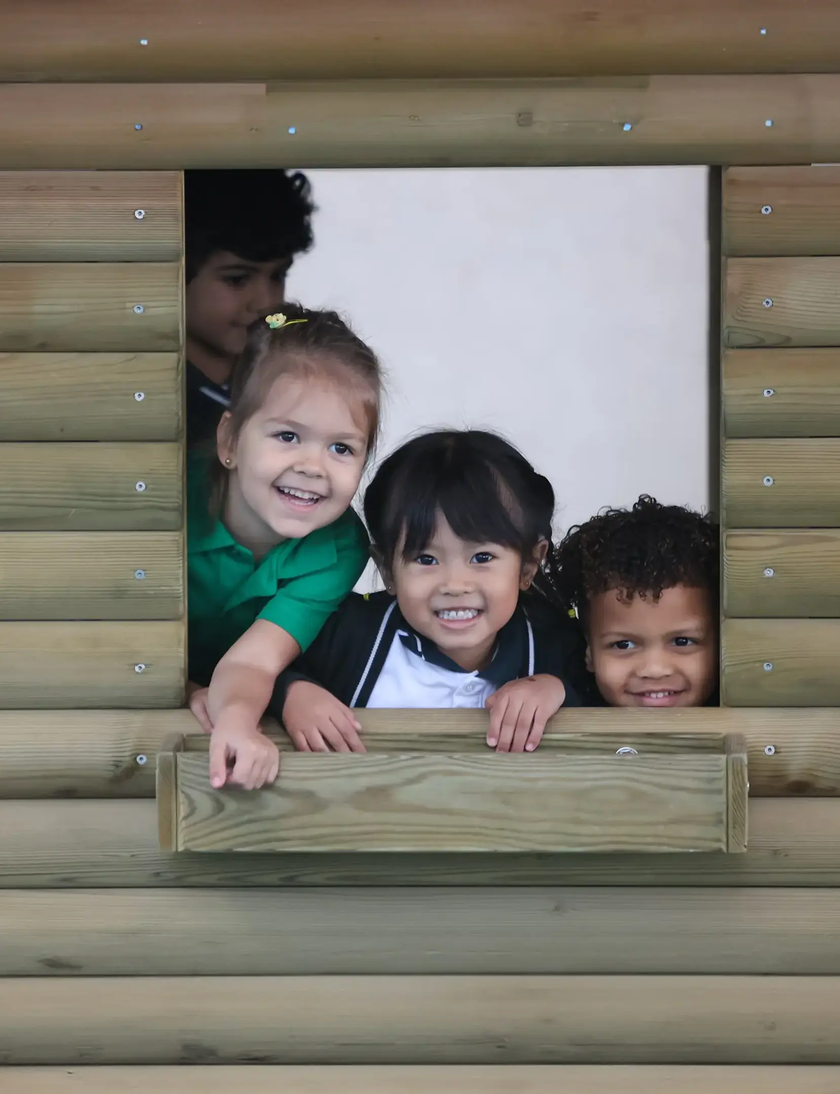 Early years students playing on plkayground and peeking out of window