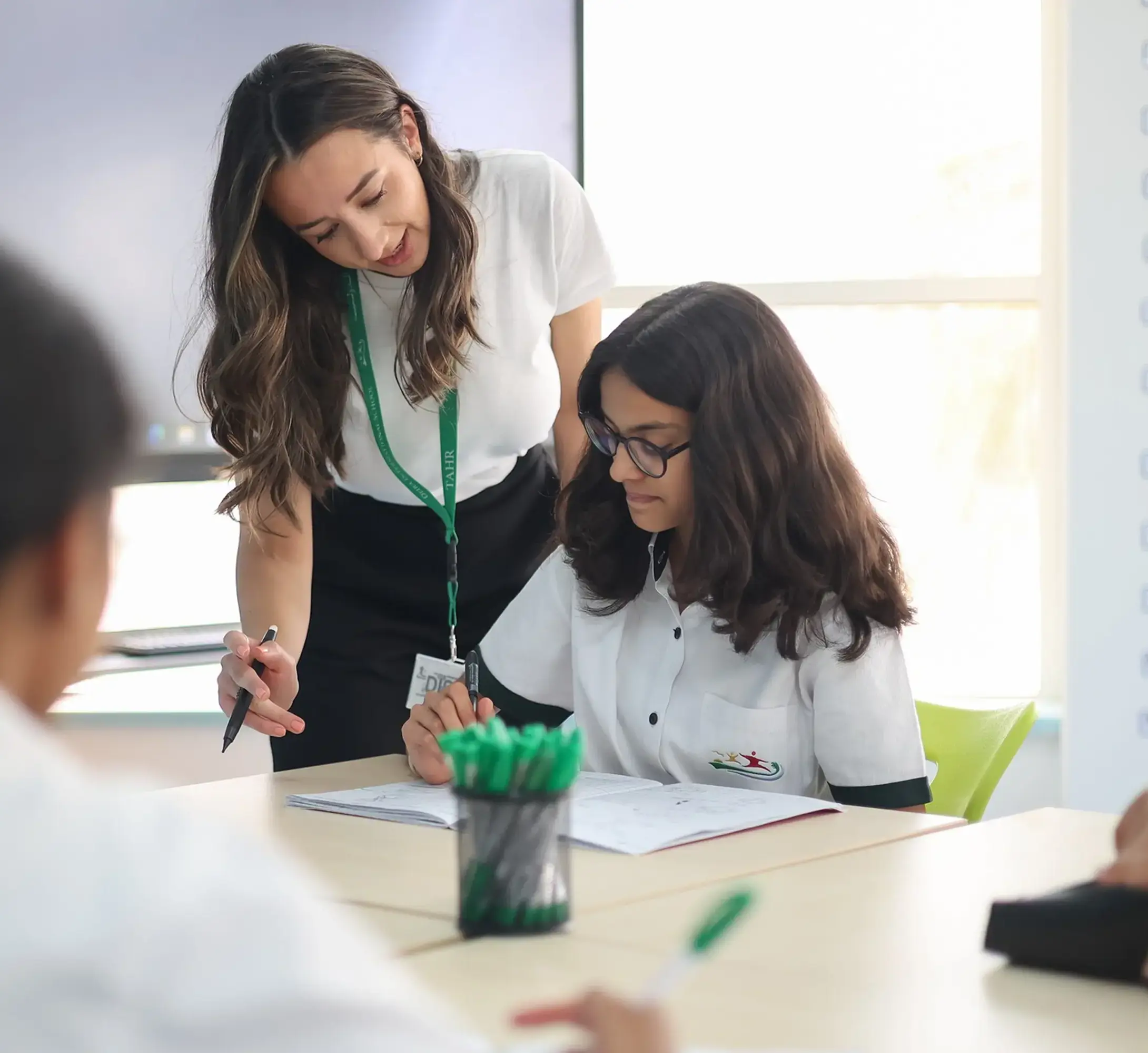 Teacher assisting student with studies in class