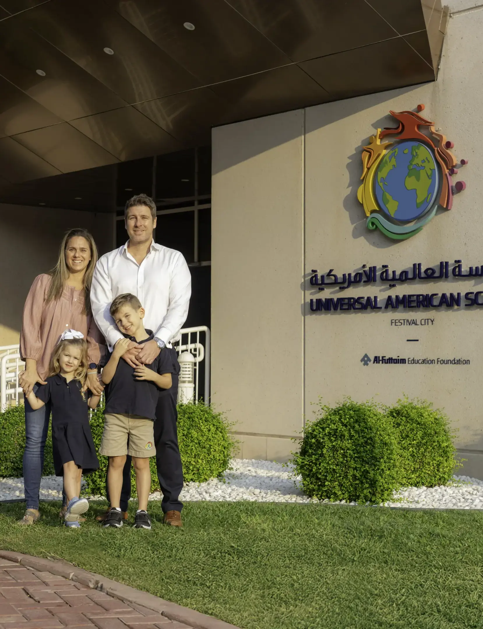 Students and parents posing in front of school building