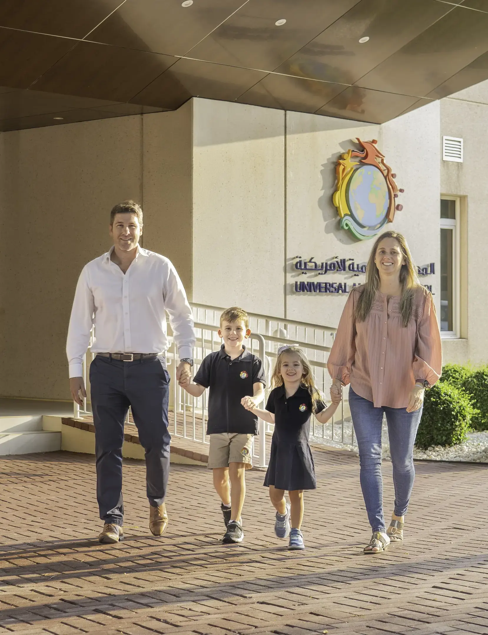 Teachers and student walking in front of school campus building