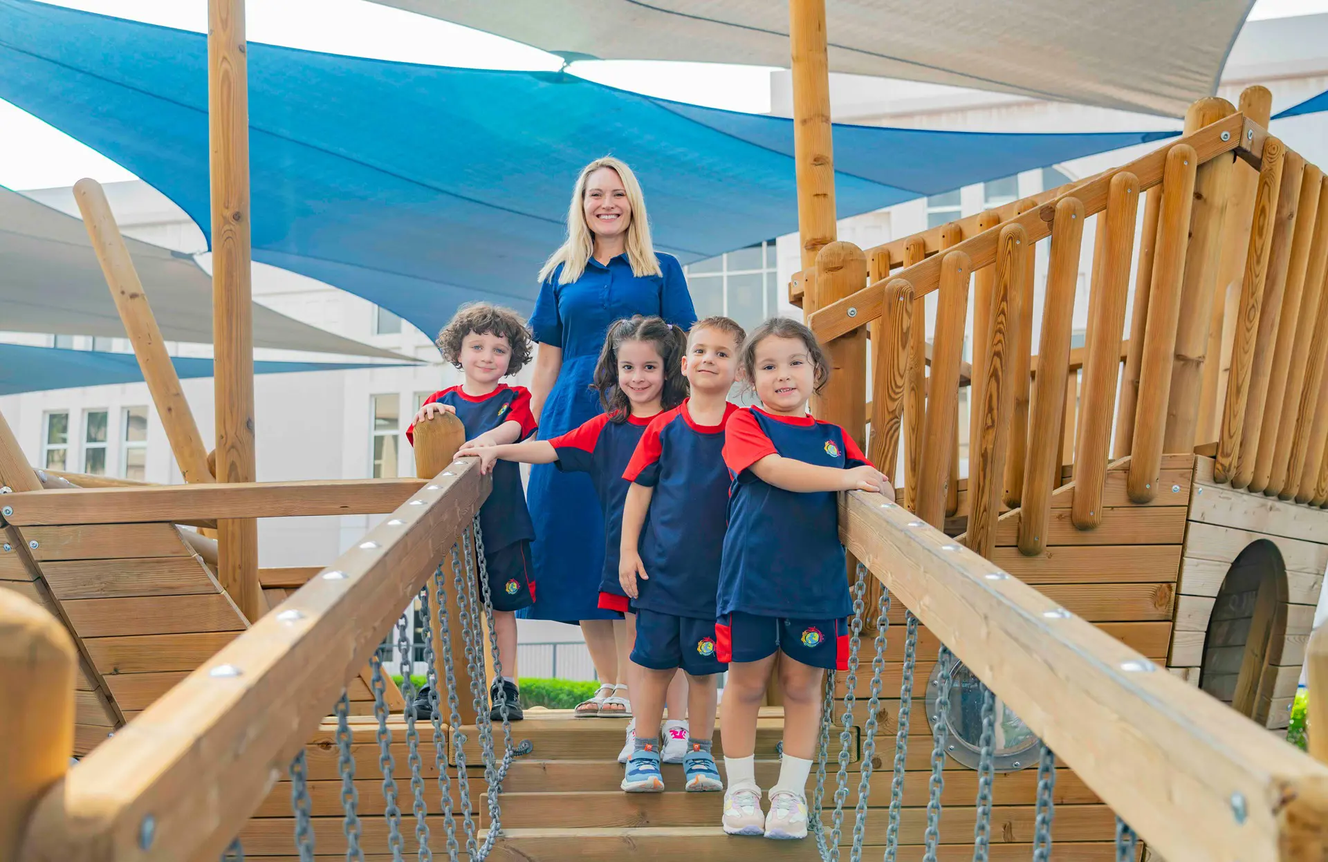 Teacher with students on wooden pirate shipjungle gym
