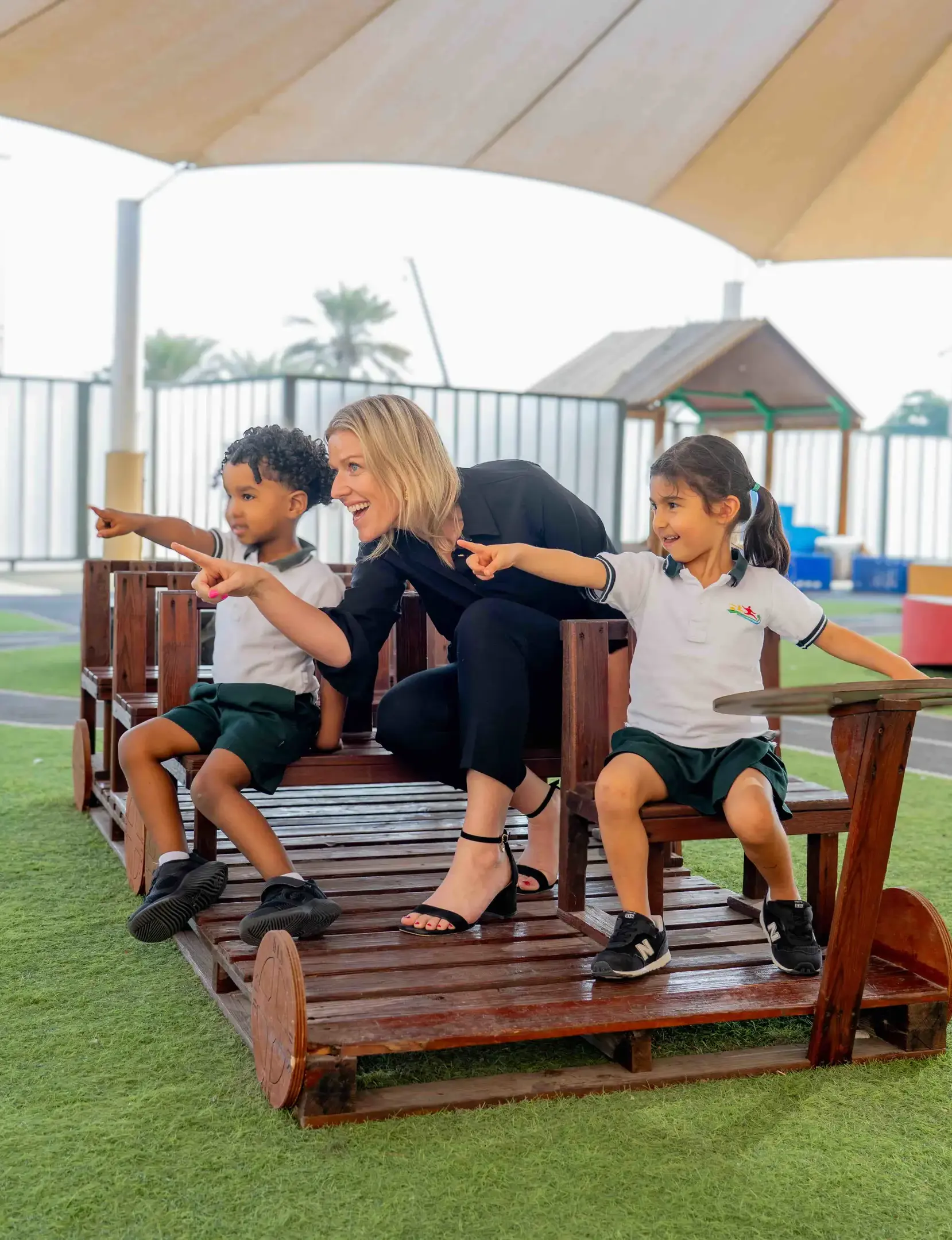 Teacher and early years students on playground